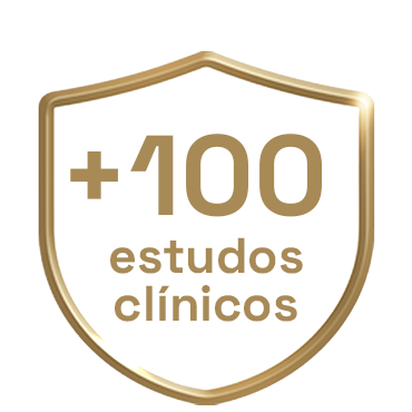Escudo dourado com o texto 'Mais de 100 estudos clínicos', sublinhando a pesquisa clínica que respalda a eficácia de Colgate Total.