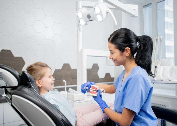 Dentista ensinando criança a escovar os dentes