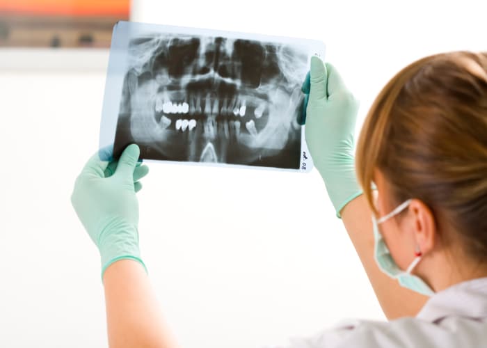 Dentista avaliando radiografia odontológica