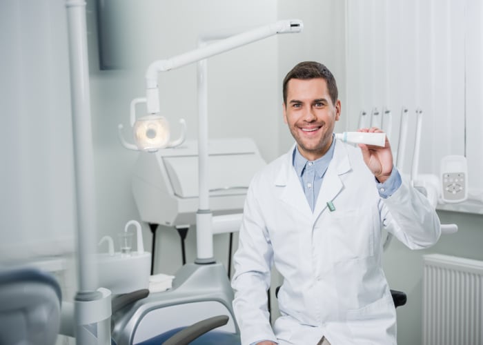 Dentista indicando creme dental aos seus pacientes