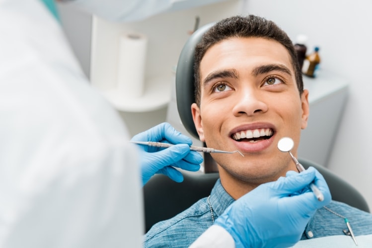 Dentista realizando avaliação em paciente