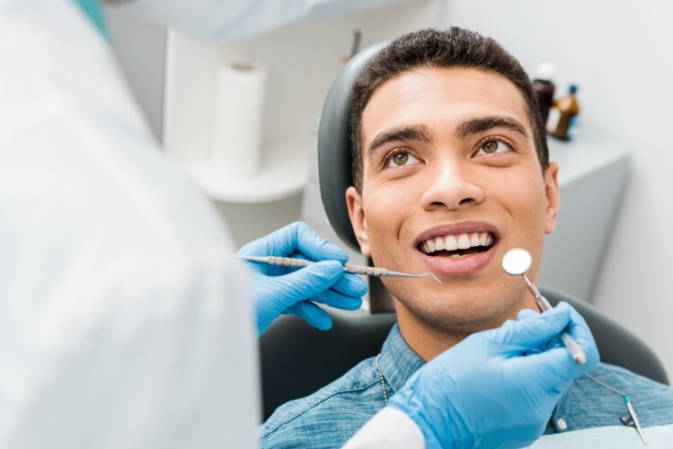 Dentista realizando avaliação em paciente Dentista realizando avaliação em paciente