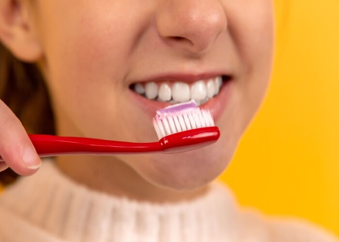 mulher escovando os dentes