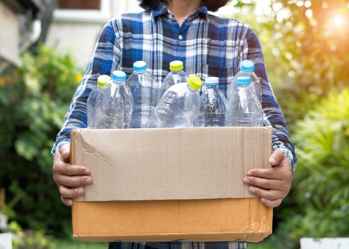 mulher separando garrafas para reciclagem
