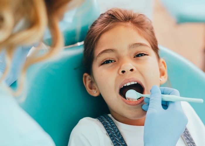 Dentista avaliando os dentes de uma criança