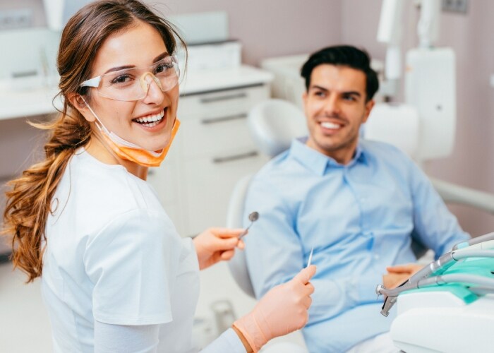Dentista avaliando o risco de cárie de uma jovem paciente