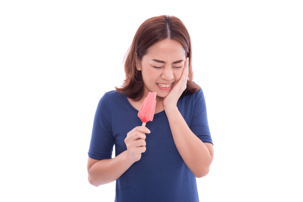 mulher tomando sorvete com sensibilidade dental